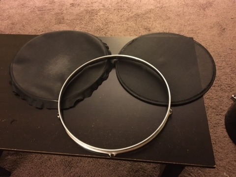 Left: Two sheets of loose window screen. Right: The single sheet sewed around the metal ring. Center: The drum head mounting mechanism that holds all of these down on top of the drum.