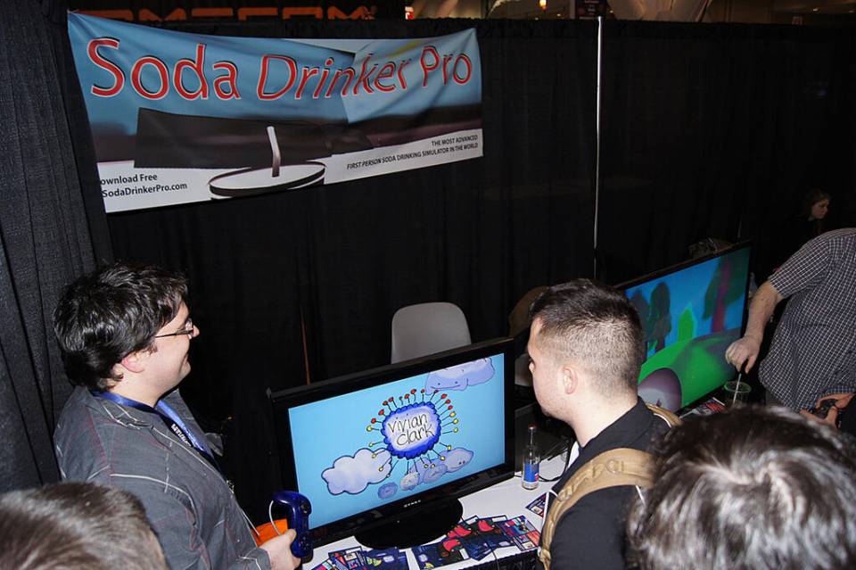 Me (right with tan backpack) with Will Brierly (left with controller) checking out Vivian Clark, a game reminiscent of WarioWare and is a fully realized game hidden within Soda Drinker Pro. 