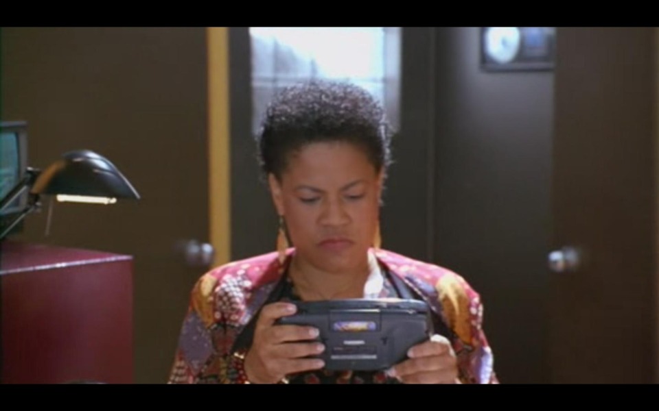  this lady is playing some kind of handheld console. know it ?